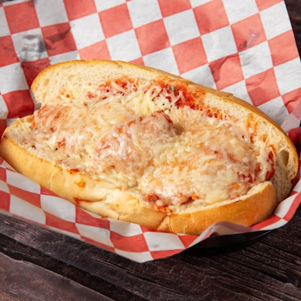 Pop's Backdoor meatball sub with melted cheese and red sauce on a checkered paper liner.