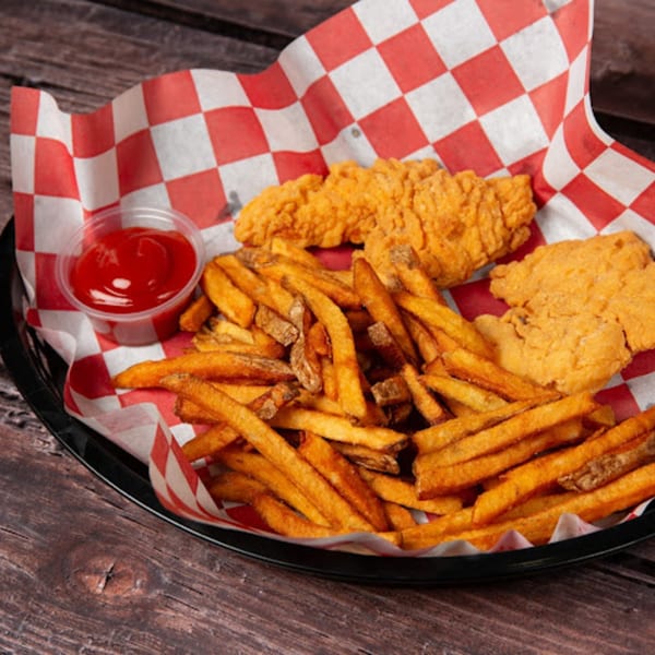 A basket of golden french fries and crispy chicken tenders with a side of ketchup.