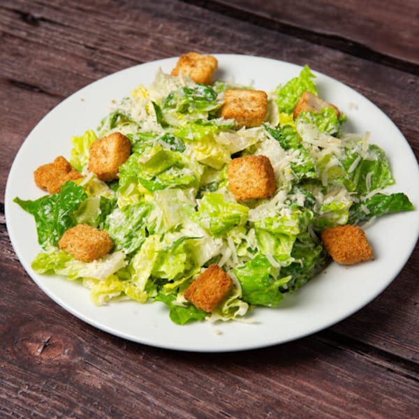 Pop's Backdoor Caesar salad with crisp romaine lettuce, shredded Parmesan, and golden croutons.