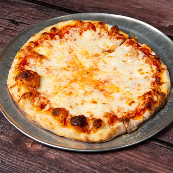 A Pop's Backdoor cheese pizza, sliced, on a metal pan over a rustic wooden table.